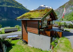 a house with a grass roof with a view of a mountain at Grande Hytteutleige og Camping in Geiranger