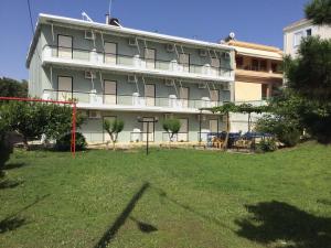 a large building with a lawn in front of it at Thomas Apartments in Kanali