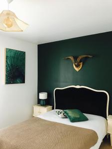 um quarto com uma cama com uma parede verde em Appartement vue sur mer île de ré em Rivedoux-Plage