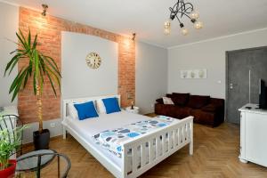 a bedroom with a white bed and a brick wall at Hostel w ogrodzie in Grudziądz