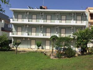 a large building with a man sitting on top of it at Thomas Apartments in Kanali