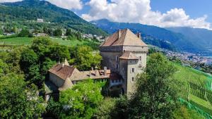 an old building on a hill with mountains in the background at Château du Châtelard | 2 persons in Montreux +9 photos
