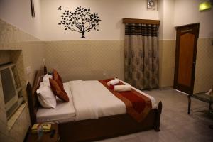 - une chambre avec un lit et un arbre sur le mur dans l'établissement Hotel City Plaza 7, à Chandigarh