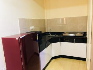 a small kitchen with a refrigerator and a sink at ABM Express Inn in Bangalore