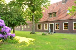 a large brick house with a yard with purple flowers at Hof Dalhaus in Lüdinghausen