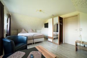 ein Schlafzimmer mit einem Bett und einem Stuhl in einem Zimmer in der Unterkunft Gästehaus Marichen in Aurich