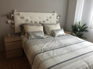 a bedroom with a large bed with two pillows at Casa Castelao, parking gratuito in Vigo