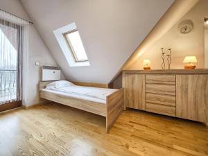 a bedroom with a bed and a dresser and a window at VisitZakopane - Mount Everest Apartment in Zakopane