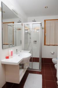 a bathroom with a sink and a shower at Residence Marisol Camere & Appartamenti - Mezzana Centre in Mezzana