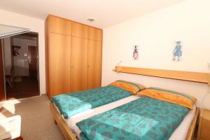 - une chambre avec un lit et une armoire en bois dans l'établissement Chesa Blais 7, à Pontresina