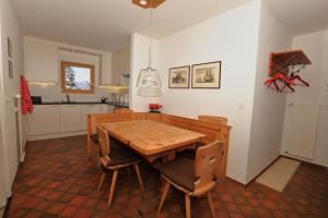 eine Küche mit einem Holztisch und Stühlen in der Unterkunft Chesa Blais 7 in Pontresina