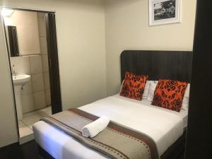 una piccola camera con letto e bagno di Businessburg Hotel a Johannesburg