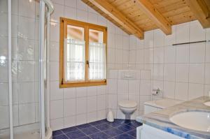 a white bathroom with a toilet and a sink at Apartment Schneerose - GRIWA RENT AG in Grindelwald +20 photos