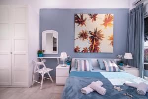 a bedroom with a bed and a painting of palm trees at Acapus Studios in Toroni