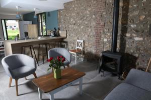 a living room with a fireplace and a table and chairs at Le Clos de la Bertinière in Bosgouet