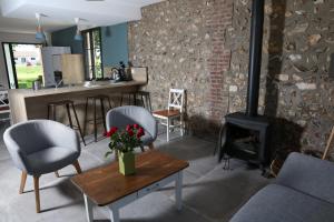 Una sala de estar con chimenea y una mesa y sillas. en Gîte Le Clos de la Bertinière, en Bosgouet