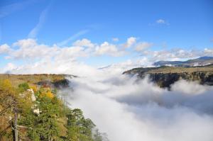 una vista de un valle de nubes en las montañas en Guesthouse Nedajno en Nedajno