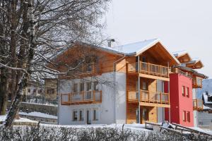 a house in the winter with snow on the ground at Residence Marisol Camere & Appartamenti - Mezzana Centre in Mezzana