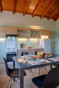 una cucina con tavolo da pranzo con sedie e tavolo con cibo di Modern eco friendly villa close to town a Pelekas