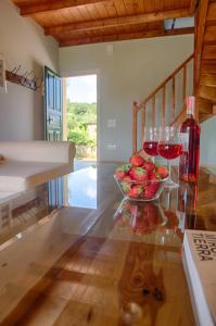 a table with glasses of wine and a bowl of fruit at Modern eco friendly villa close to town in Pelekas