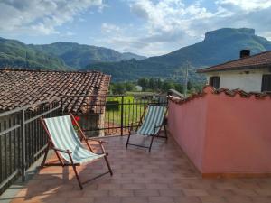 2 sillas en un balcón con montañas en el fondo en L'Antico Borgo, en Fornaci di Barga