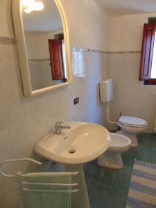 y baño con lavabo, aseo y espejo. en L'Antico Borgo, en Fornaci di Barga