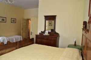 a bedroom with two beds and a dresser and a mirror at Agriturismo Tenuta Goro Veneto in Ariano nel Polesine