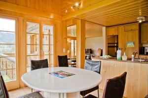 a kitchen and dining room with a white table and chairs at Apartment Schneerose - GRIWA RENT AG in Grindelwald