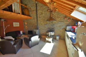 a kitchen and living room with a stone wall at Gites-Clairiere-Ardenne in Louftémont