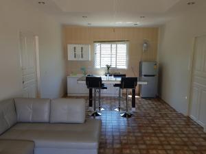 a living room with a couch and a kitchen at Poolside Bungalows in Khao Lak