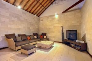 a living room with a couch and a flat screen tv at Villa Esperanto Seminyak in Seminyak