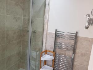 a bathroom with a shower with a glass door at Church View at Plover Cottage Lindley in Huddersfield