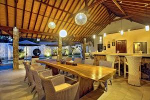 Villa Esperanto Seminyak في سمينياك: غرفة طعام مع طاولة وكراسي خشبية