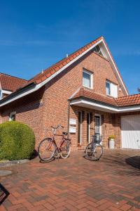 deux vélos garés devant une maison en briques dans l'établissement Ferienwohnung Ostfriesenglück, à Leer