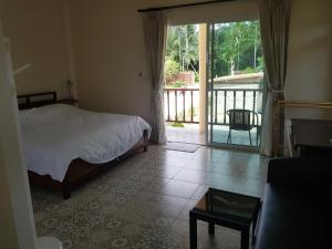 a bedroom with a bed and a sliding glass door at Poolside Bungalows in Khao Lak +23 photos