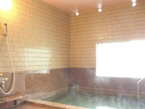a bathroom with a bath tub with water in it at Hotel Senke in Myoko