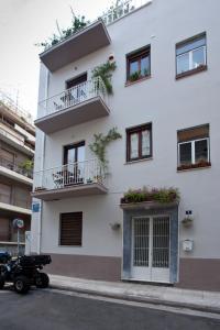 un edificio bianco con balconi e piante di Exarcheia House ad Atene