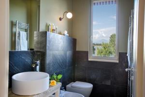 a bathroom with a sink and a toilet and a window at Le Ali Del Frassino in Peschiera del Garda