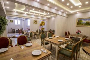 Andalouse Suite Hotel في طرابزون: غرفة طعام مع طاولات وكراسي خشبية