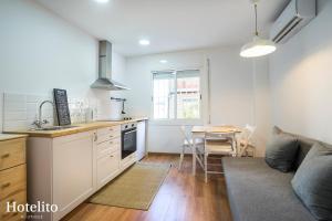 a kitchen and living room with a couch and a table at Hotelito Boutique Mercat in Hospitalet de Llobregat