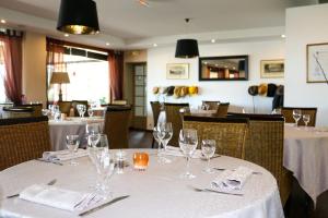 - une table dans un restaurant avec des verres à vin dans l'établissement Hôtel - Restaurant La Chaloupe, à Le Port-des-Barques