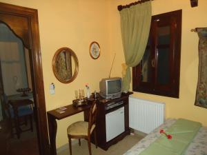 a bedroom with a desk with a television on it at Ktima Samanli in Kissos