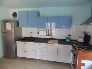 una cucina con armadi blu e frigorifero in acciaio inossidabile di Apartment Villa Luna a Magazzini