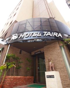 een hotel tamara bord op de voorzijde van een gebouw bij Hotel Taira in Naha
