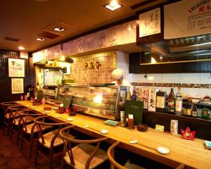 a bar in a restaurant with a chef preparing food at Hotel Taira in Naha