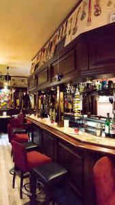 a bar in a restaurant with red chairs and a counter at Hotel Skada City Cölln in Cologne