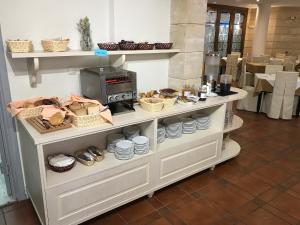 a kitchen with a counter top and a shelf full of food at Fortezza Hotel in Rethymno
