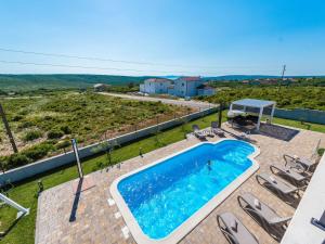 - une vue sur la piscine avec des chaises et une maison dans l'établissement Lovely Villa in Debeljak with Heated Private Pool, à Debeljak