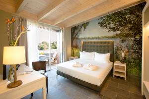a bedroom with a bed with a painting on the wall at Le Ali Del Frassino in Peschiera del Garda