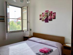 サンタ・カテリーナにあるVilletta Dei Gliciniのベッドルーム(ベッド1台、窓付)